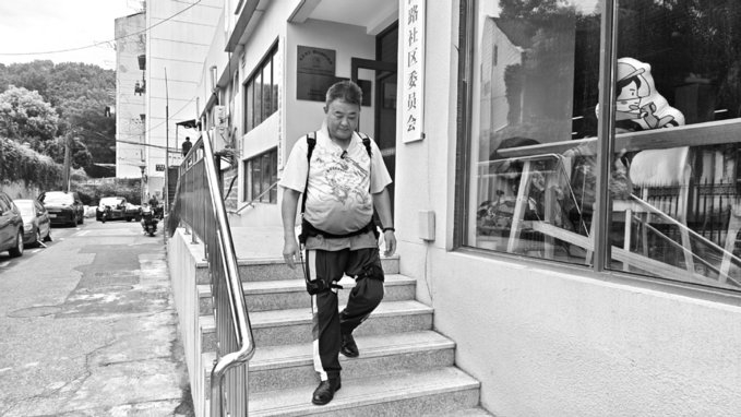 记者带着外骨骼机器人请老人试用